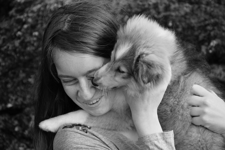 Signs your dog loves you: A smiling woman hugging a dog