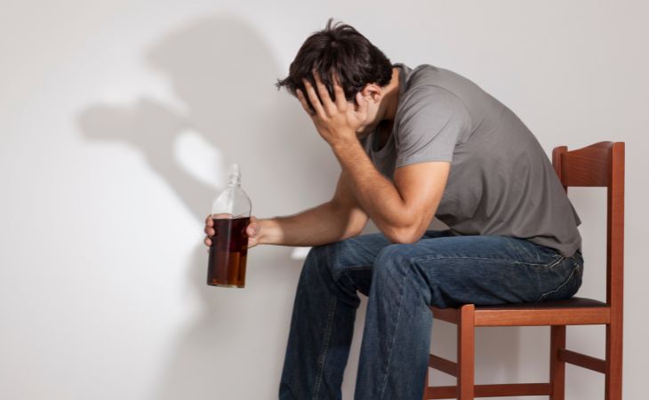 How to recognize toxic family dynamics: Man with a liquor bottle and his shadow drinking behind him