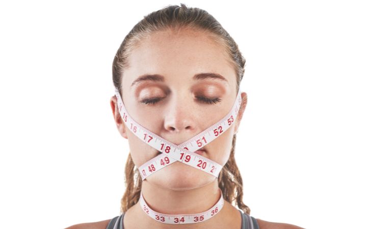 How to recognize toxic family dynamics: Woman with a measuring tape around her face