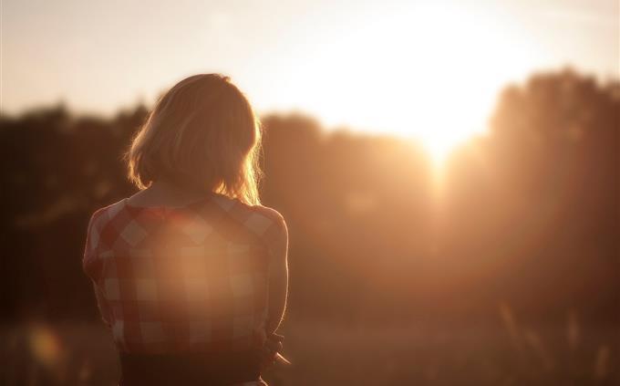 A test of flowers and romance: a woman in front of a sunset