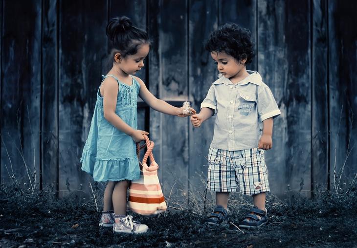 Things to teach children about love: a girl giving a flower to a boy