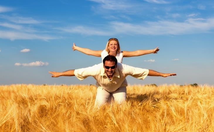 What to do when frustrated in a relationship: couple in a field raising their hands to the sides