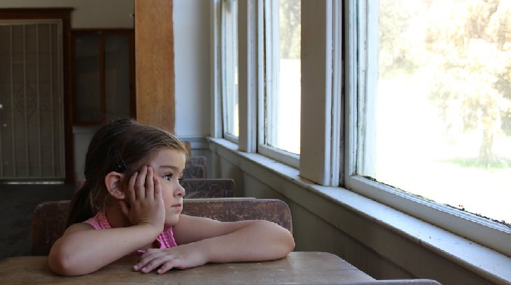 Surprising brain facts: A girl sitting at a table staring out the window