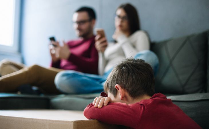 How to Deal with Toxic Family Members: Parents Busy on Phones While Child is Sad Next to Them