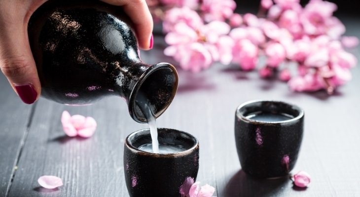 Health benefits of alcoholic beverages: Sake poured from a bottle into a glass