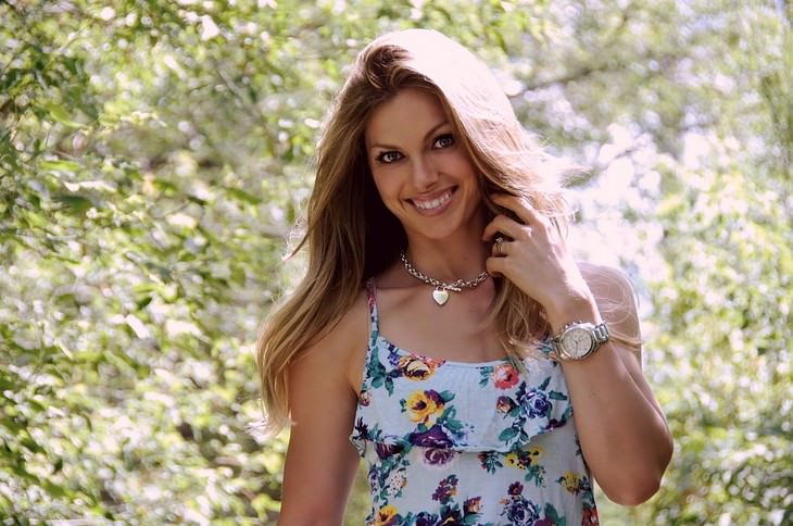 A woman in a floral dress smiling at the camera