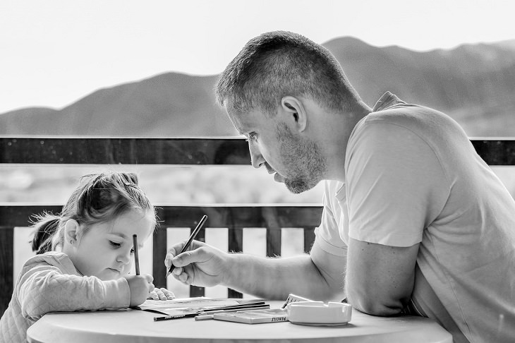 4 Stages of Raising Children According to the Tibetans: A Father Sitting with His Daughter, Helping Her Fill in Work Sheets