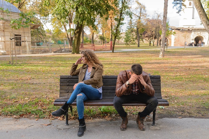 Complaints in Relationships: A couple on a bench with the man bowing his head and the woman looking away