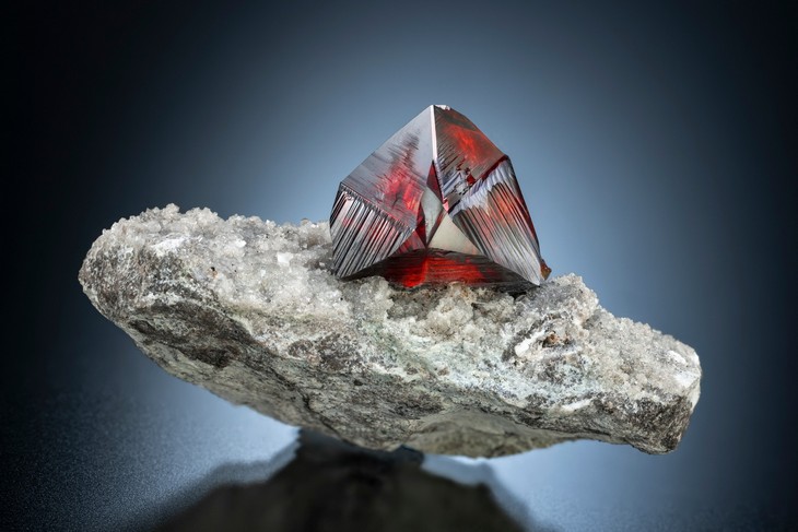Red Sphalerite twin crystal with excellent lustre and striation, on Calcite coated matrix from the ElmwoodMine, Carthage, Smith County, Tennessee, USA.