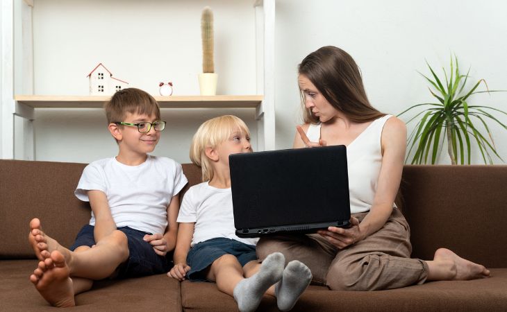 mother showing laptop to children