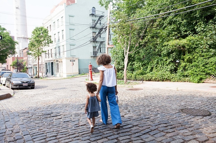 Tips to prevent bedwetting: Mother and daughter walking hand in hand on the street