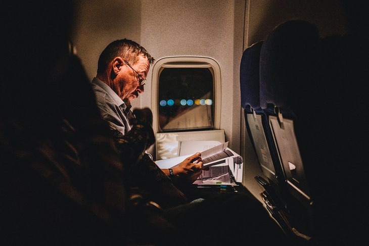 Things to avoid on a flight: man sitting next to a window in an airplane