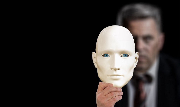 Things not to be ashamed of and hide from a therapist: A man holds a mask in front of his face