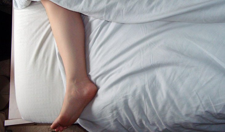 Mindfulness meditation: a woman's foot lying in bed