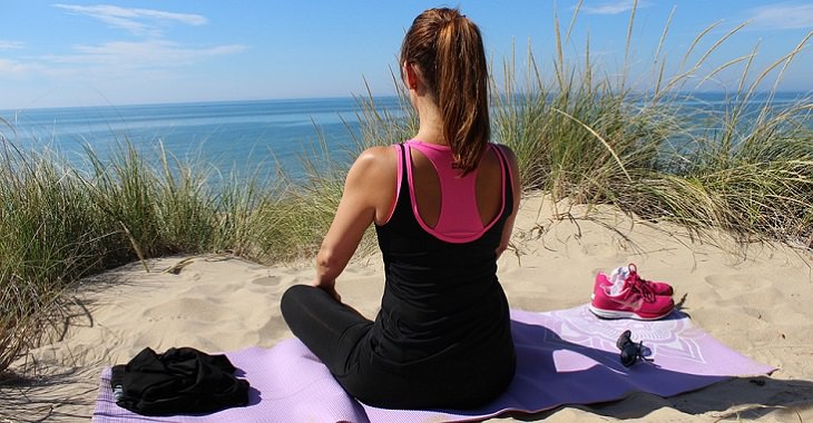 Mindfulness meditation: a woman meditating on the beach