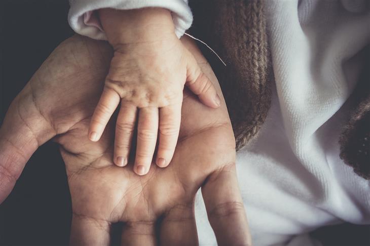 Parenting Styles: Baby's hand on an adult's hand