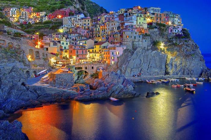 The Amalfi Coast in Italy: Colorful houses on a cliff lit up at night