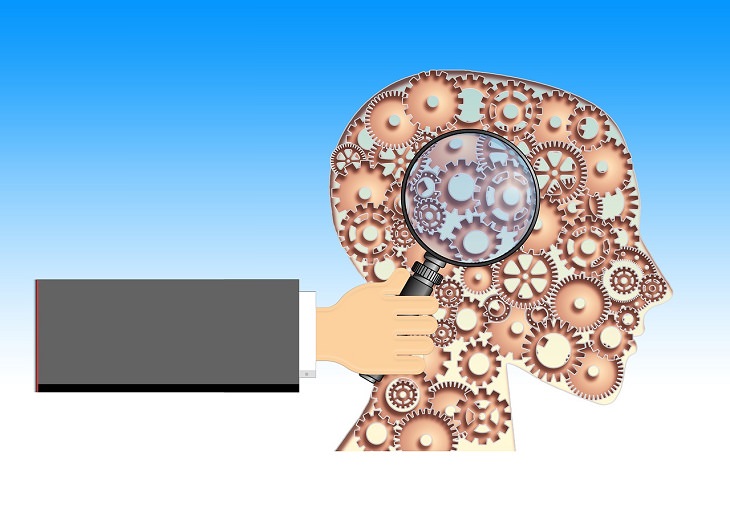 Research on improving brain functions with age: Illustration of a brain as gears and a hand bringing a magnifying glass closer to it