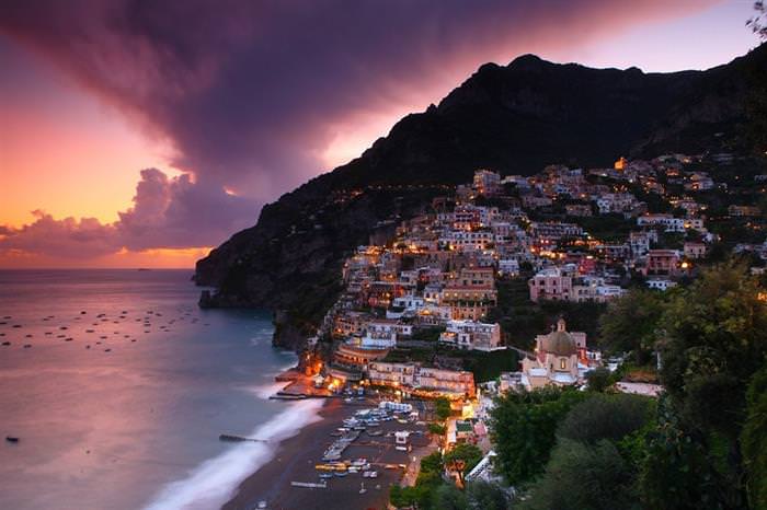 The Amalfi Coast in Italy: Sunset with houses on a hill in the background