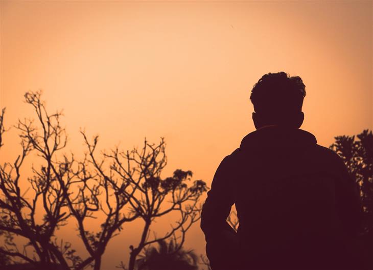 How to Overcome the Fear of Disappointing Others: Silhouette of a person sitting in nature at twilight