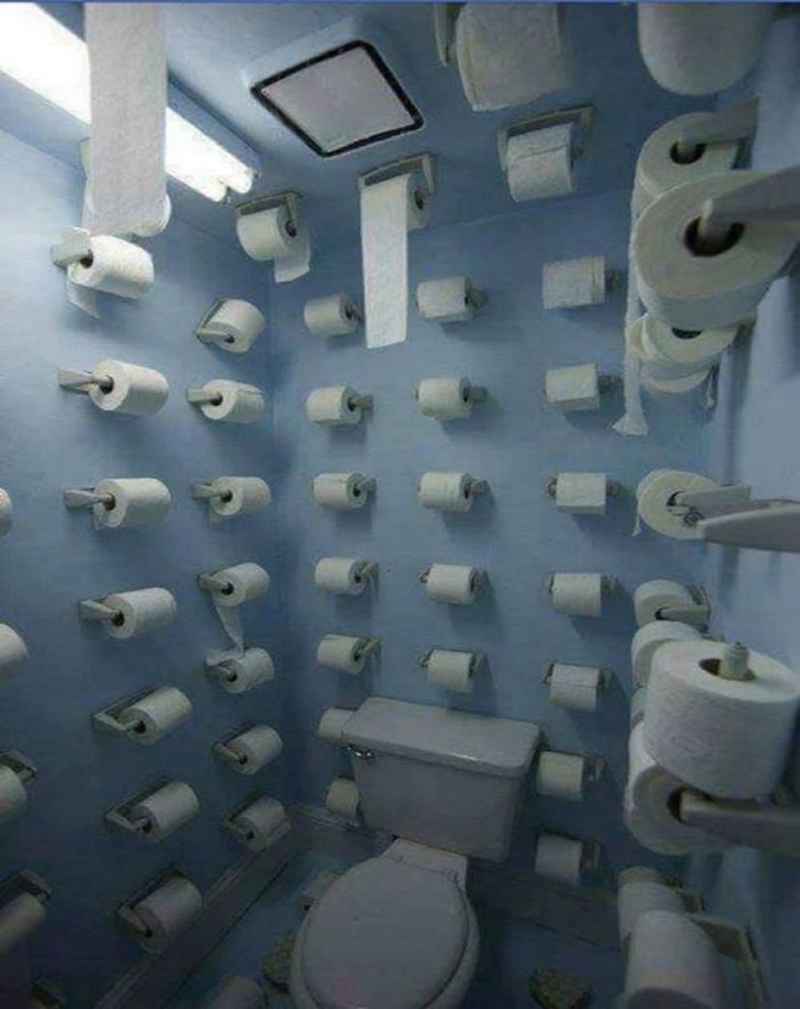 Bizarre Toilets: A toilet stall with lots of toilet papers hanging on the walls and ceiling