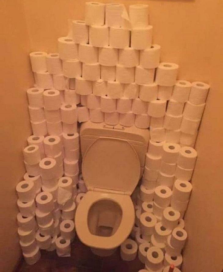 Bizarre Toilets: A toilet stall with lots of toilet papers behind it