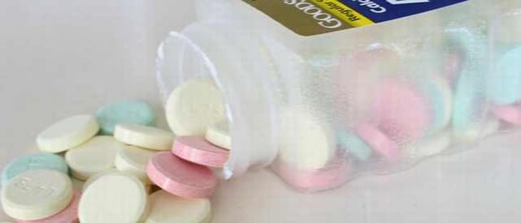 Antacid tablets spilling out of a container