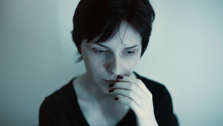 Phrases to get life back on track: Woman with a frightened look holding a hand in front of her face