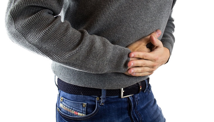 Shiatsu treatments and their benefits: Man holding his stomach in pain