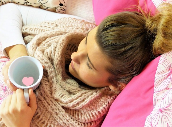 Uses of eucalyptus oil: Woman lying on a couch with a cup in her hand