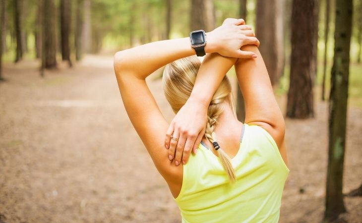 How to Break a Cycle of Negative Thoughts: Woman stretching in the woods