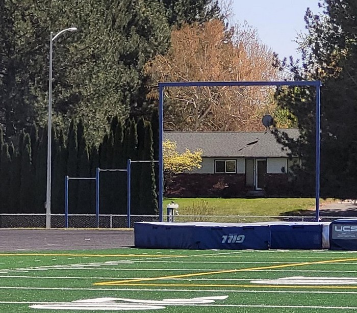 Funny perfectly timed photos: gate on a sports field with a house behind it