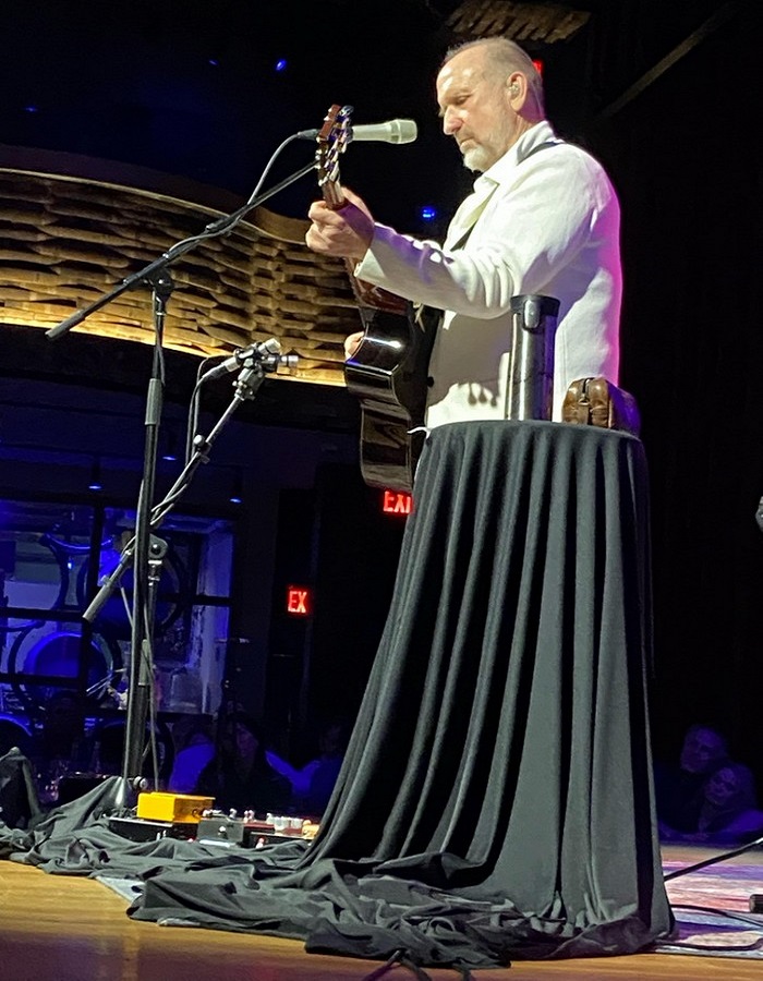 Funny perfectly timed photos: guitarist standing behind tablecloth that looks like a dress