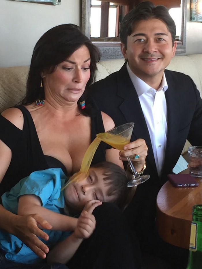 Funny perfectly timed photos: woman accidentally pouring drink on boy during family photo