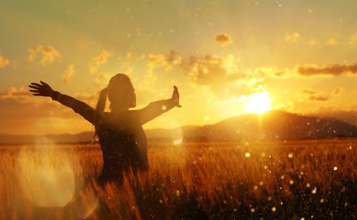 Wabi-Sabi Lessons: Woman standing in a field raising her arms