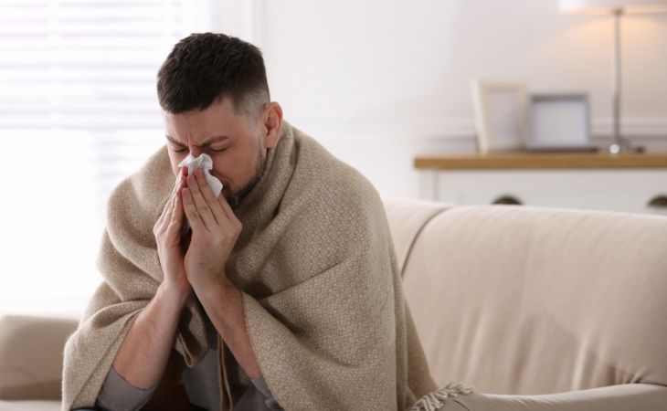 Why you shouldn't drink coffee with cold medications: Man blowing his nose