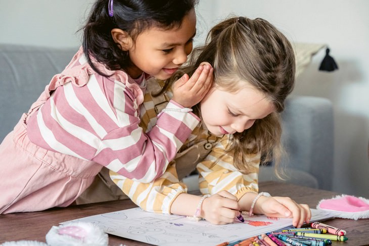 Psychological Tricks for Parents: A girl whispering into another girl's ear