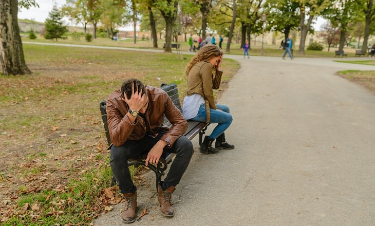 Casal magoado num banco de parque