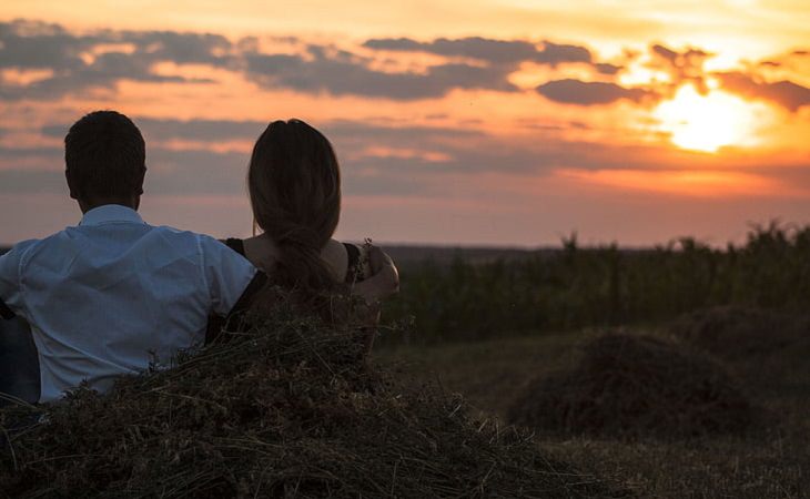 Casal abraçado ao pôr do sol