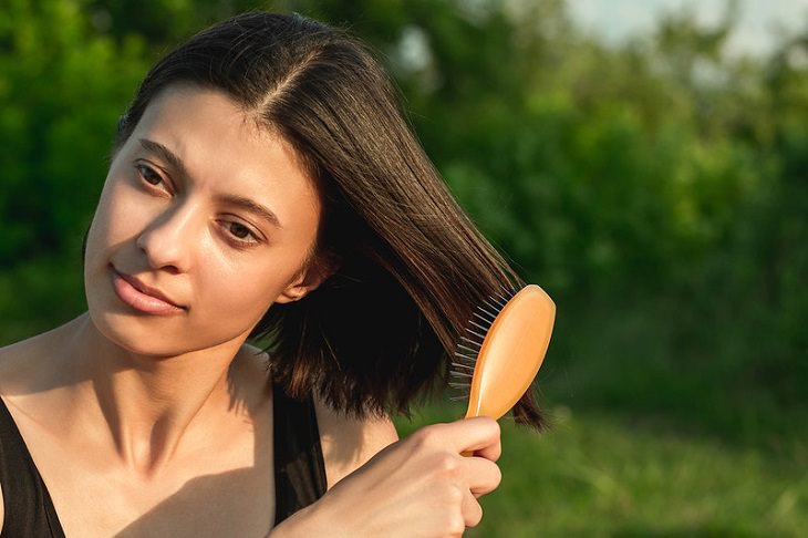 Mistakes in Hair Brushing: A woman brushing the ends of her hair