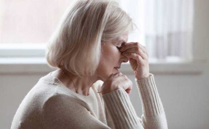 Study on excessive fatigue and mortality: An elderly woman holding her head from exhaustion