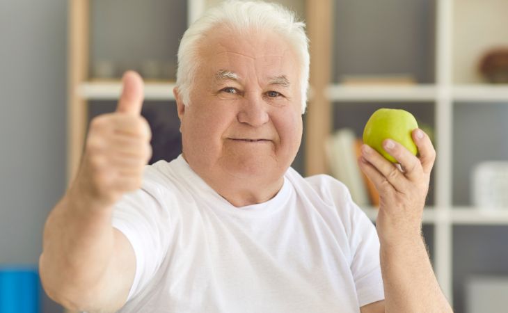 New Ways to Reduce Dementia Risk: An elderly man holding an apple