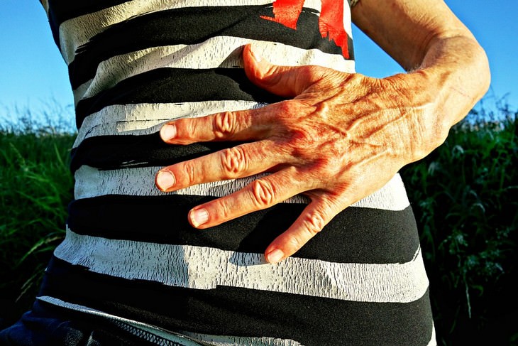 Effects of stomach problems on the body: A woman holding her stomach