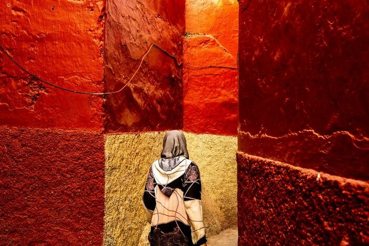 Photos from the 1839 Awards photography competition: Woman walking among giant stone walls in vibrant red colors