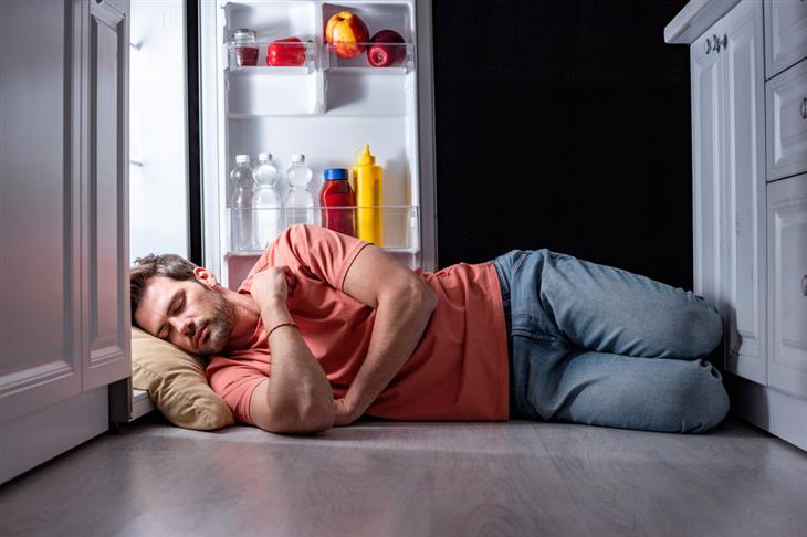 Guide to sleeping with an air conditioner or fan: Man sleeping in front of an open refrigerator