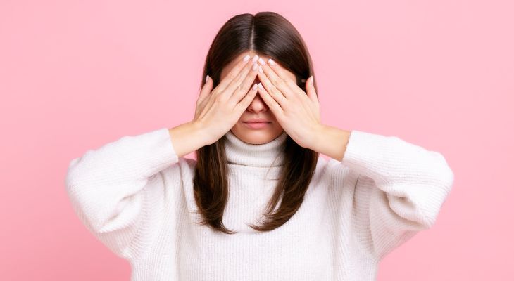 How to identify emotions and the message they convey: A woman hiding her eyes behind her hands