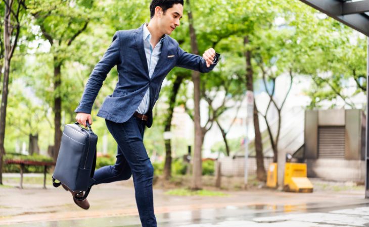 Advantages of people who are late: A man running and looking at his watch