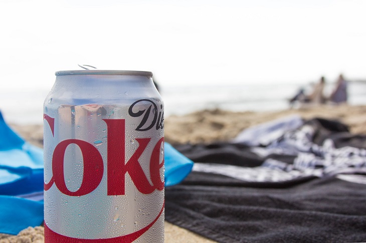 Foods to avoid giving children: A can of diet carbonated drink against a beach background