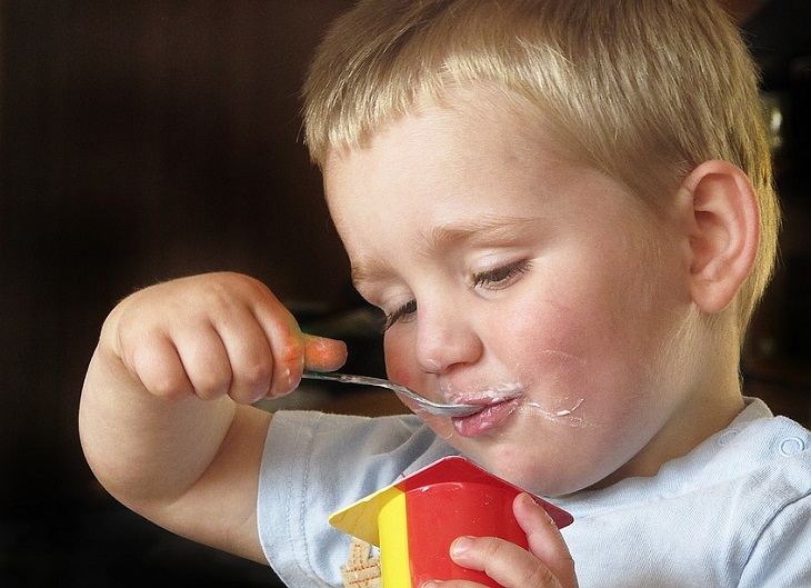 Foods to avoid giving children: A child eating yogurt