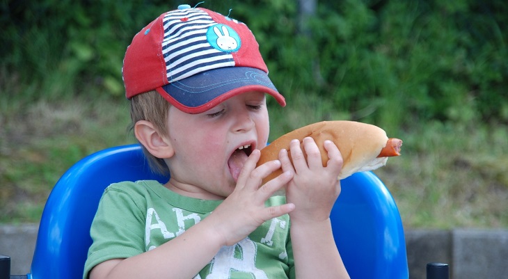 Foods to avoid giving children: A child eating a hot dog